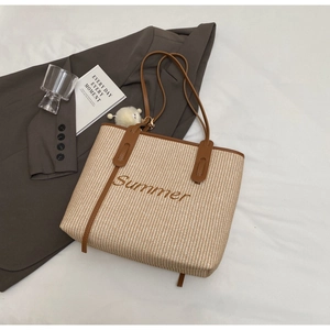 Detailaufnahme der gewebten Stroh-Tote-Bag mit Summer-Stickerei und braunem Lederbesatz