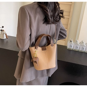 Detail view of two-tone bucket bag in pebble leather with a cute elephant charm