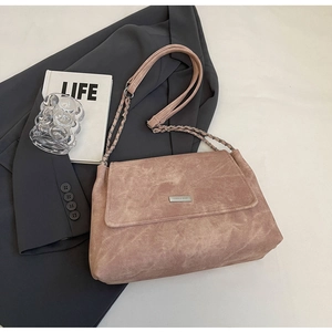 Detailaufnahme einer rosa Cord-Umhängetasche mit einer silbernen Metallschnalle und Logo