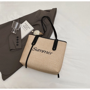 Detailaufnahme der Stroh-Tragetasche mit Summer-Stickerei, Lederriemen und Bommel-Anhänger
