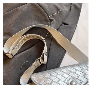 Detalle de la correa ancha ajustable de tela en un bolso bandolera tejido para mujeres