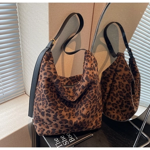 Détail du sac seau à imprimé léopard avec bandoulière cuir et boucles dorées