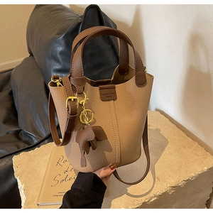 Close-up of two-tone brown bucket bag with lychee texture leather and elephant charm