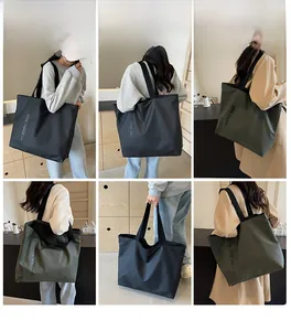 Detail view of large nylon tote bags in black and olive green with wide shoulder straps
