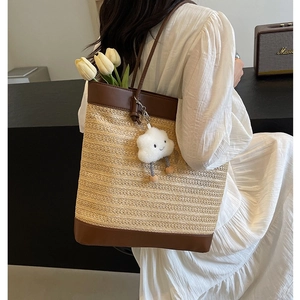 Minimalist straw woven tote bag with brown leather trim and cloud pendant for summer