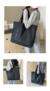 Detail of a large black nylon tote bag showing spacious interior and casual shoulder style