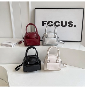 Mini borse Boston chic in argento, bordeaux, nero e crema esposte su delle piattaforme