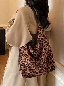 Sac seau hobo chic à imprimé léopard avec lanières noires porté par un mannequin
