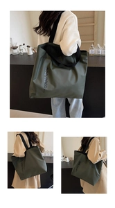 Detail of olive green nylon tote bag featuring black wide strap and brand logo print