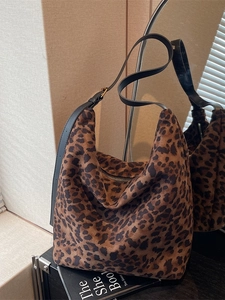 Sac hobo chic à imprimé léopard avec bandoulière en cuir noir sur présentoir studio