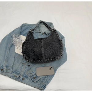 Détail du sac demi-lune en denim noir délavé avec fermeture éclair et bandoulière