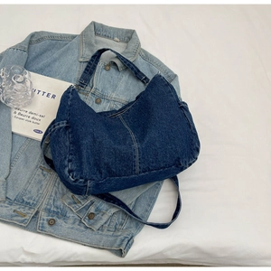 Détails du sac hobo en denim bleu foncé avec quincaillerie argentée et poche latérale