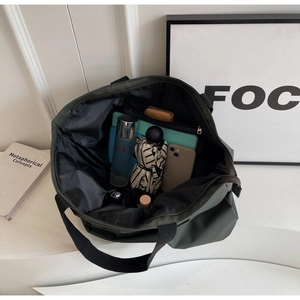 Detailed view of spacious black interior on the large army green nylon tote bag