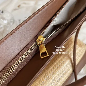 Detail of smooth golden metal zipper and brown textured leather tote bag interior