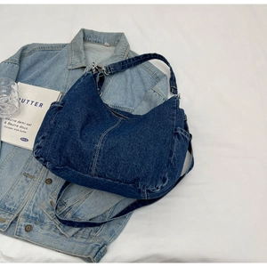 Vue détaillée du sac bandoulière en denim bleu foncé avec des surpiqûres blanches