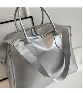 Detail view of the silver metallic satin travel bag with gray adjustable shoulder strap