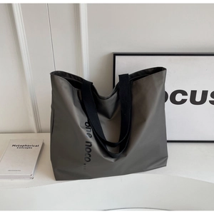 Detail of high-density nylon tote bag with printed text and wide black fabric handles