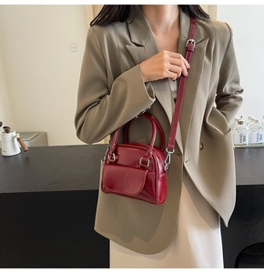 Dettaglio della mini borsa a tracolla rosso vino lucida con manico superiore ed elegante