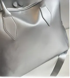 Close-up of the soft matte silver fabric texture and durable handle on a tote bag