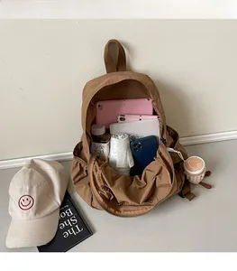 Spacious interior of brown nylon backpack showing storage for tablets and books