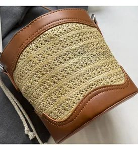 Detail of woven straw texture and brown leather trim on a stylish bucket beach bag
