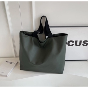 Macro view of high-density nylon tote bag in olive green with black straps