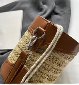 Detailed macro view of woven straw bag with premium brown leather trim and silver clasp