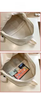 Detail view showing internal compartments of white canvas backpack for tablet and essentials
