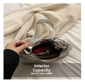Detalle del interior del bolso plateado que muestra el almacenamiento para cosméticos