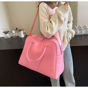 Detail of pink travel tote featuring lychee texture fabric and silver metal hardware accents