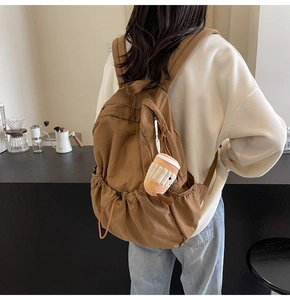 Brown casual nylon backpack featuring a cute coffee cup plush charm and drawstring side pocket