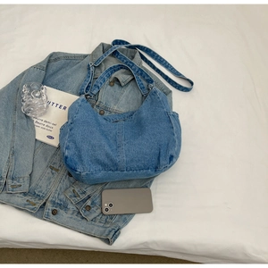 Vue détaillée du sac hobo en denim bleu avec bandoulière réglable et base plissée