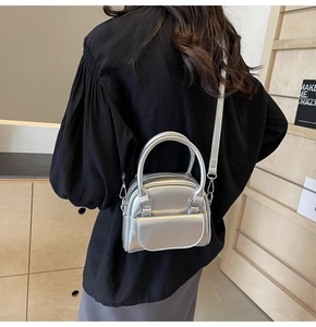 Mini borsa a tracolla argento indossata con tracolla regolabile e doppi manici