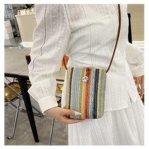 Vertical striped woven mini crossbody bag with a porcelain snap button on a model