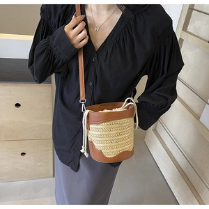 Detail of straw bucket bag with leather patchwork and cotton drawstring closure