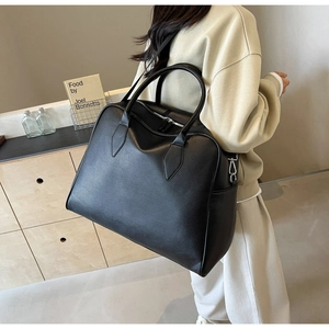 Detailed view of large black tote bag with litchi grain texture and detachable strap