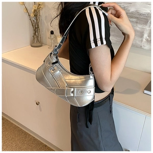 Close-up of metallic silver crescent bag with Y2K buckle details and textured leather