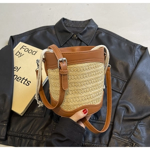 Close-up of straw bucket bag texture with leather trim and thick cotton rope handle