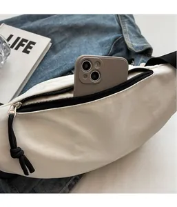 Detail view of white canvas crossbody bag showing inner storage for a smartphone