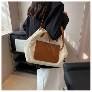 Chic canvas tote bag with brown leather details shown on model in a modern interior setting