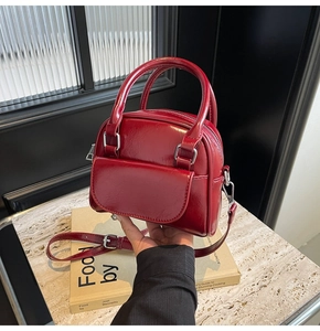 Dettaglio della mini borsa rossa in vernice lucida con hardware argento e tracolla