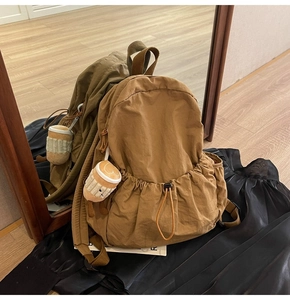 Brown nylon backpack with drawstring pocket and cute coffee cup plush charm detail