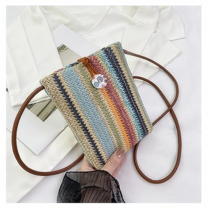 Close-up of colorful striped woven straw bag with decorative button and brown strap