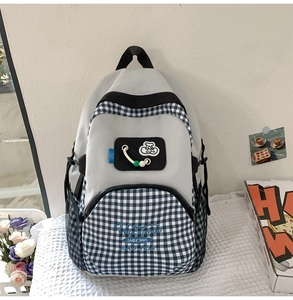Detail of grey and blue plaid patchwork canvas backpack with cherry embroidery and pockets