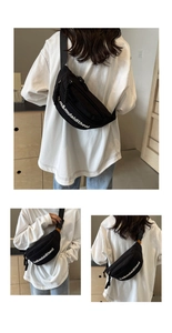 Detail of black canvas crossbody bag with white lettering and orange brand label