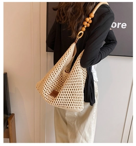Détail du sac hobo tissé main avec perles en bois naturel et maille de corde texturée