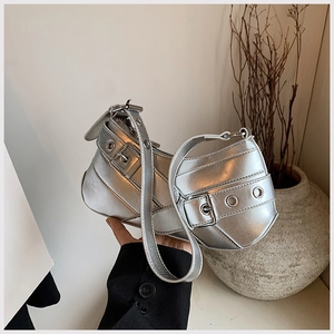 Detail of silver metallic crescent bag with punk buckle straps and eyelet hardware