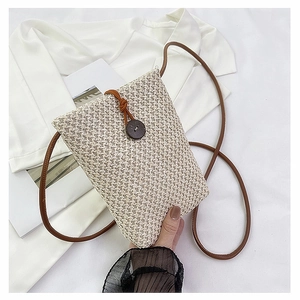 Detailed close-up of woven texture on minimalist cream crossbody bag with wooden button closure