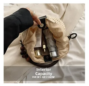 Détail du sac cabas en paille tressée montrant l'intérieur spacieux et l'anse en bois