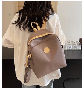 Detailed back view of a minimalist brown nylon backpack with stylish yellow contrast trim